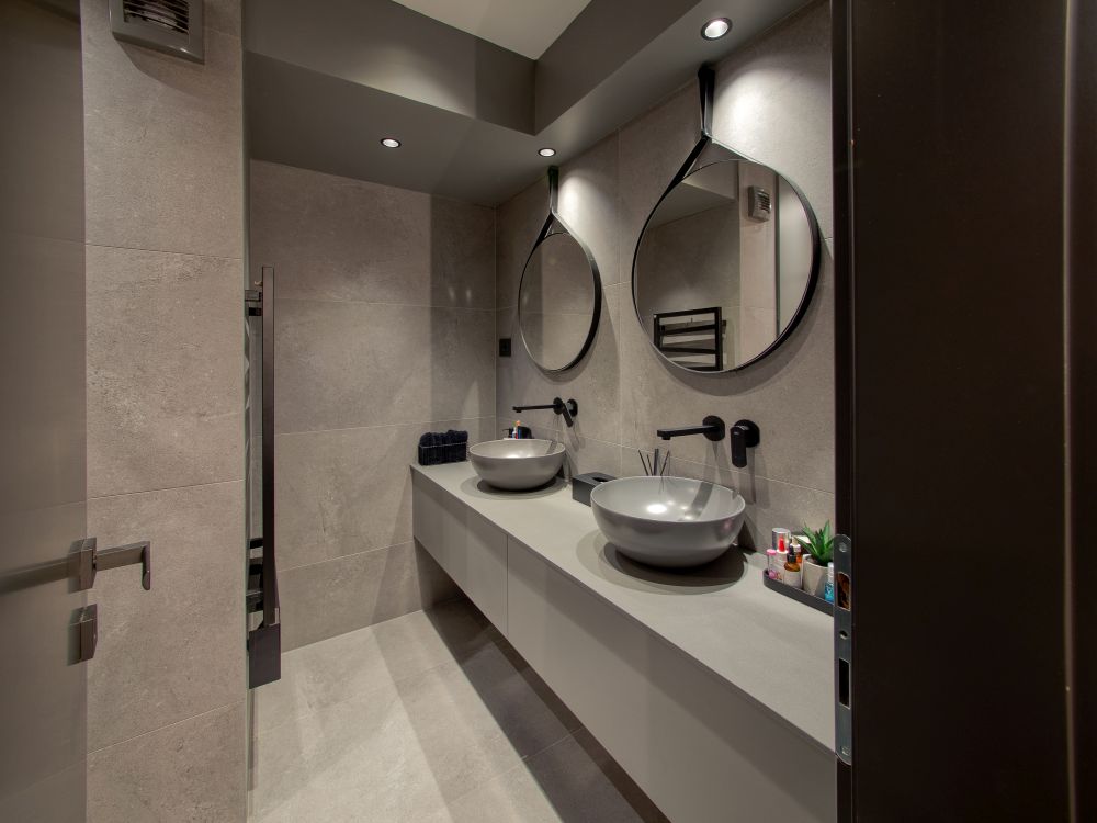 Subdued accent lighting and soft grey tones give the master bathroom a very inviting and pleasant look