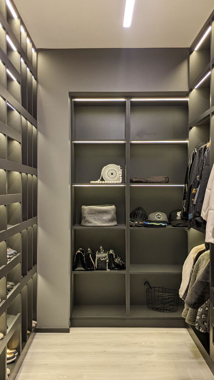 The walk-in closet matches the overall design of the bedroom and the apartment's color scheme