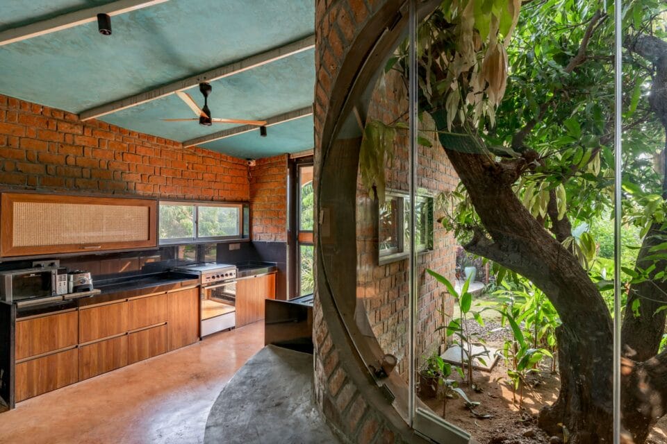 the view of a home's interior with a small kitchen and large window revealing a tree