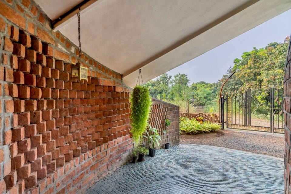 a textured brick wall lines the opening to a home