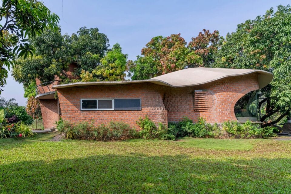 the exterior of a brick home with a concrete roof and trees surrounding it