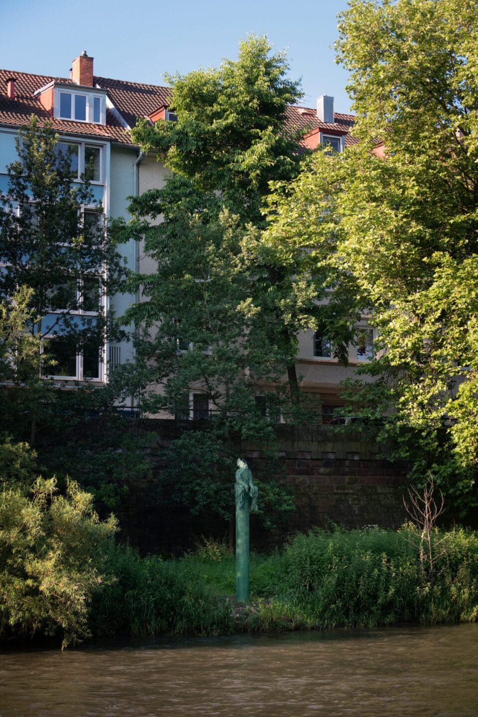 a tall fountain stands next to a river