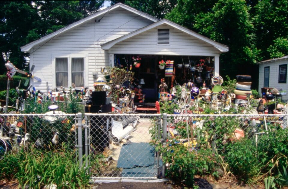 a photo of a yard covered in colorful found object assemblages